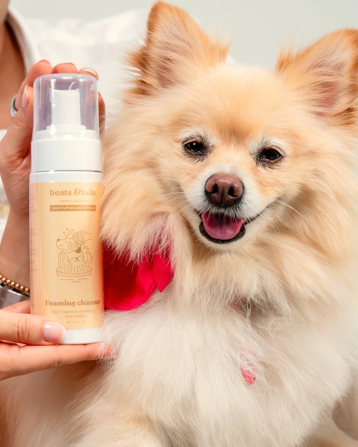 Mila next to a bottle of Foaming Cleanser